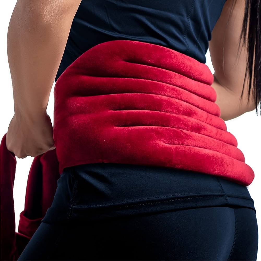 person using heating pad for lower back pain relief at home